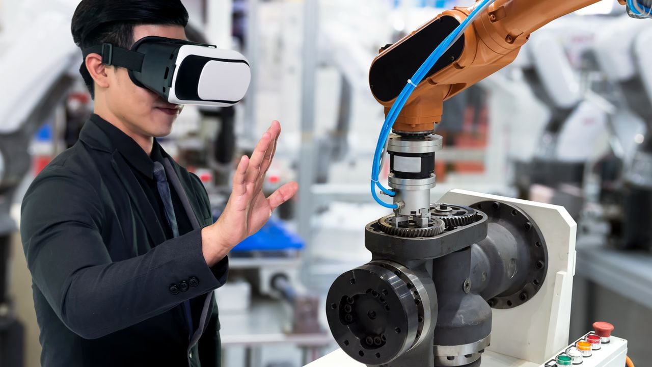 Tecnología de realidad virtual en la industria 4.0. Traje de hombre de negocios con gafas VR para ver el servicio AR, motor de monitoreo térmico para verificar, destruir parte de la máquina de brazo de robot inteligente en fábrica inteligente.