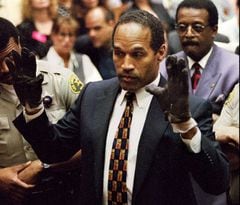 O.J. Simpson, con los guantes manchados de sangre encontrados por la policía de Los Ángeles y presentados como prueba en el juicio por asesinato de Simpson, muestra sus manos al jurado a petición del fiscal Christopher Darden en esta fotografía de archivo del 15 de junio de 1995 como su abogado Johnnie Cochran, Jr.