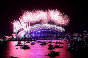 Los fuegos artificiales de Nochevieja estallan sobre el icónico Harbour Bridge y la Opera House (L) de Sydney durante el espectáculo de fuegos artificiales el 1 de enero de 2022. (Photo by DAVID GRAY / AFP)