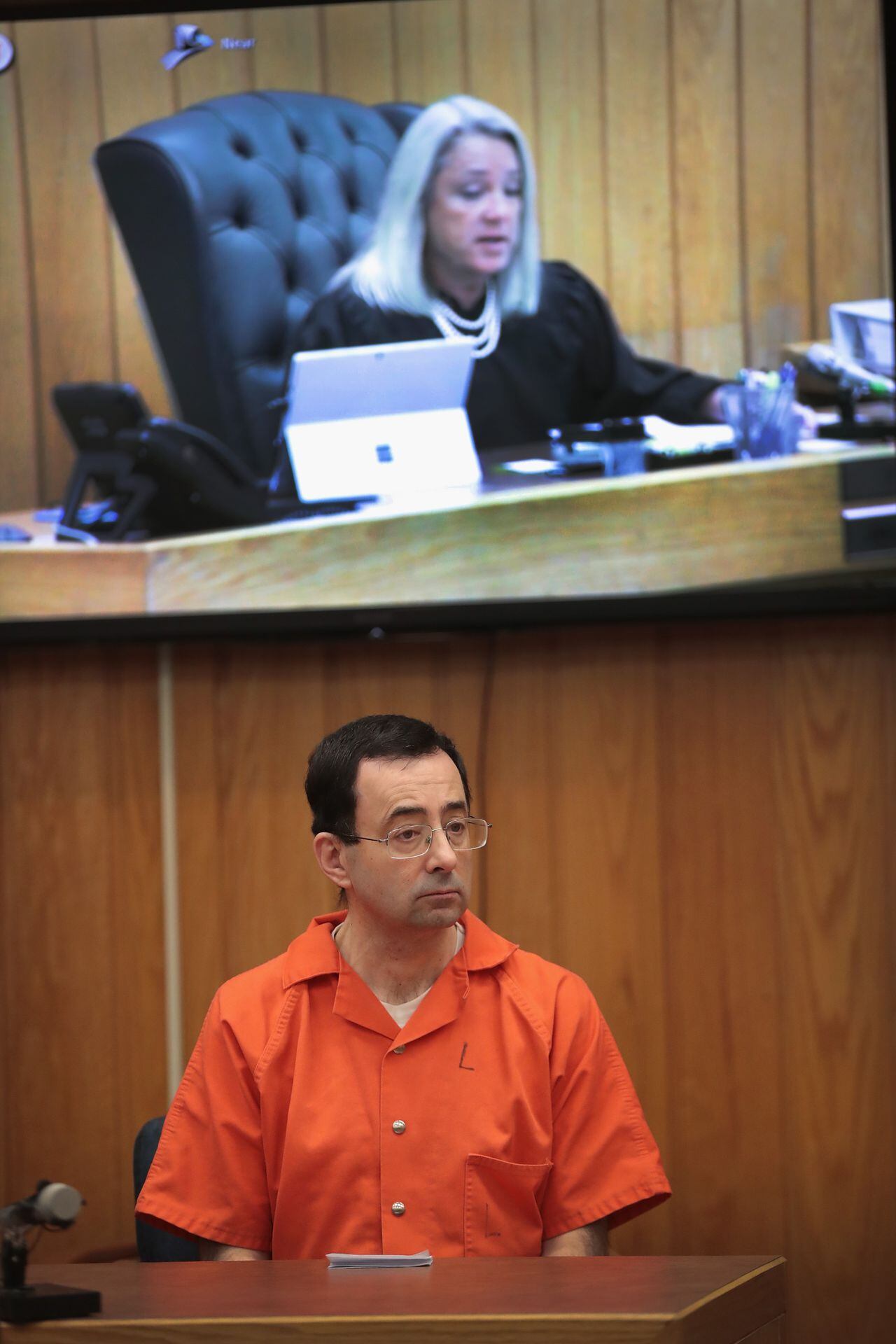 CHARLOTTE, MI - FEBRUARY 05:  Larry Nassar listens as he is sentenced by Judge Janice Cunningham for three counts of criminal sexual assault in Eaton County Circuit Court on February 5, 2018 in Charlotte, Michigan. Nassar has been accused of sexually assaulting more than 150 girls and young women while he was a physician for USA Gymnastics and Michigan State University. He is currently serving a 60-year sentence in federal prison for possession of child pornography. Last month a judge in Ingham County, Michigan sentenced Nassar to an additional 40 to 175 years in prison after he plead guilty to sexually assaulting seven girls.  (Photo by Scott Olson/Getty Images)