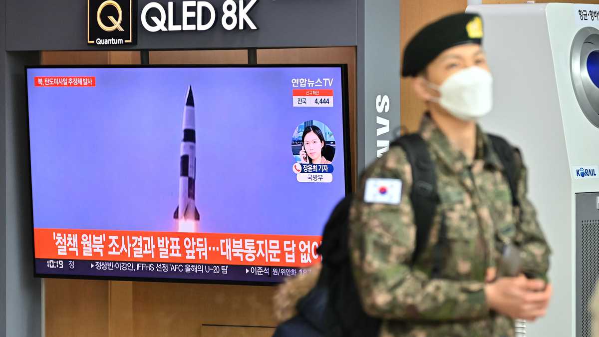 Un soldado surcoreano pasa junto a una pantalla de noticias de televisión que muestra imágenes de archivo de una prueba de misiles de Corea del Norte, en una estación de tren en Seúl el 5 de enero de 2022.