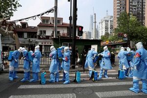 Trabajadores con trajes protectores se preparan para desinfectar un complejo residencial en el distrito de Huangpu, luego del brote de la enfermedad por coronavirus (COVID-19) en Shanghái, China, 20 de abril de 2022. Foto REUTERS/China Daily