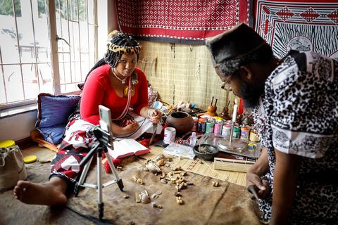 Traditional healer Gogo Kamo (L), does an online consultation with a client in her consultation room in Kempton Park, South Africa on April 16, 2021. - Known as "sangomas" in Zulu language, traditional healers are qualified herbalists, councillors and community mediators as well as diviners.