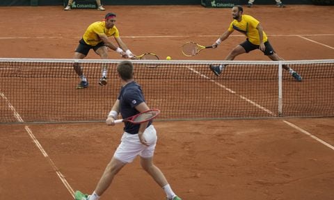Neal Skupski of Britain, bottom, returns a ball to Robert Farah, left, and Juan Sebastian Cabal, of Colombia, during their Davis Cup qualification doubles match in Cota, Colombia, Saturday, Feb. 4, 2023. (AP/Fernando Vergara)
