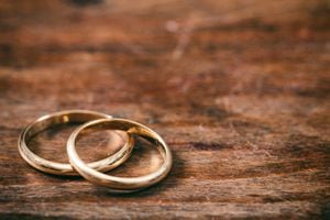 Un par de anillos de bodas de oro sobre fondo de madera, espacio de copia
