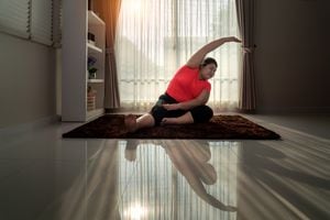 Mujer asiática con sobrepeso ejercicio de yoga Posición de flexión lateral sentada sola en el suelo en casa, ejercicio de meditación de yoga en casa. Las mujeres gordas cuidan la salud y quieren perder el concepto de peso.