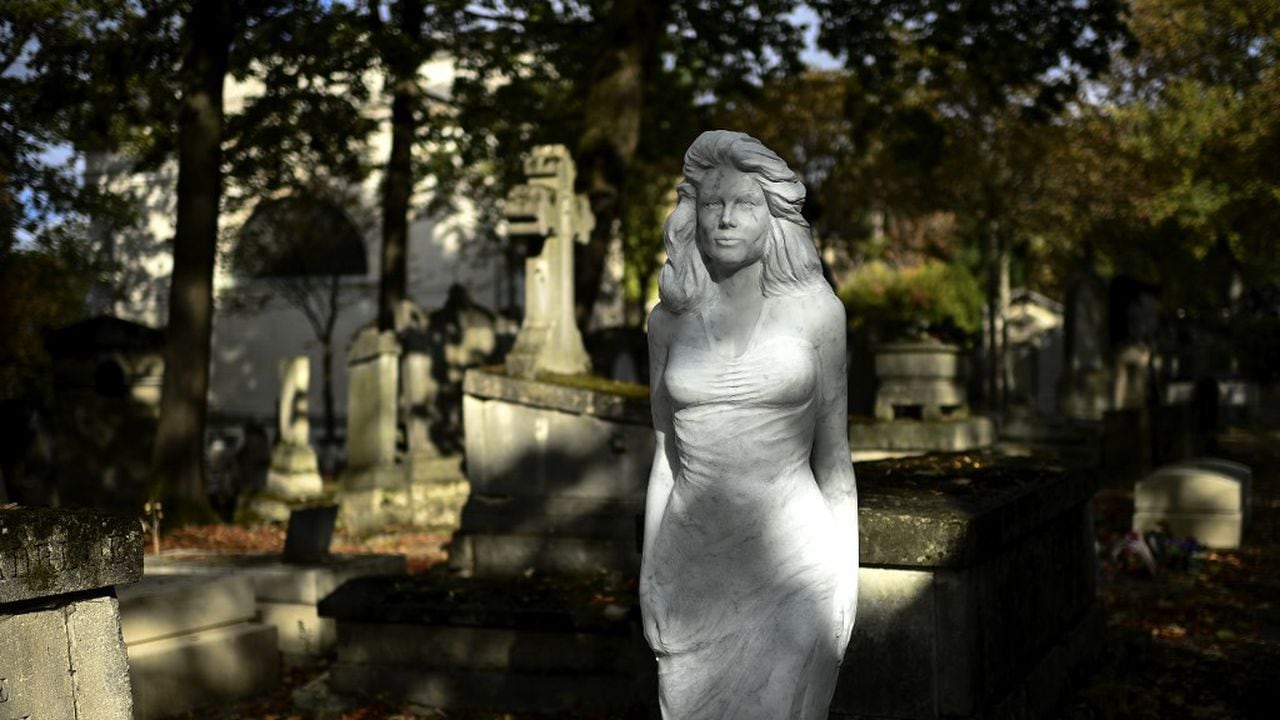 This picture shows the life-size statue of an unidentified woman adorning an empty grave at the Pere Lachaise cemetery in Paris on September 25, 2020. - The sculpture of a woman, an empty grave, an anonymous backer and a hint of megalomania: a Carrara marble statue of woman appeared in the middle of July in an alley of the Parisian cemetery of Pere Lachaise. (Photo by Christophe ARCHAMBAULT / AFP)