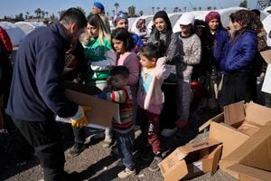 Un voluntario, a la izquierda, distribuye alimentos para las personas que perdieron sus casas en el devastador terremoto, mientras hacen fila con cajas para recibir suministros de ayuda en un campamento improvisado, en la ciudad de Iskenderun, en el sur de Turquía, el martes 14 de febrero de 2023. (AP Photo/Hussein Malla)