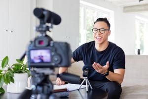 Hombre joven asiático hermoso que hace un video blog. Vlogger masculino de grabación de contenido en cámara digital. influencer