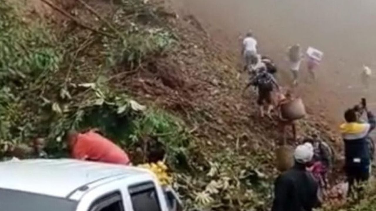 Derrumbe en Chocó: la comunidad debe bajar a los enfermos de los carros para hacer trasbordo pasando por el deslizamiento.