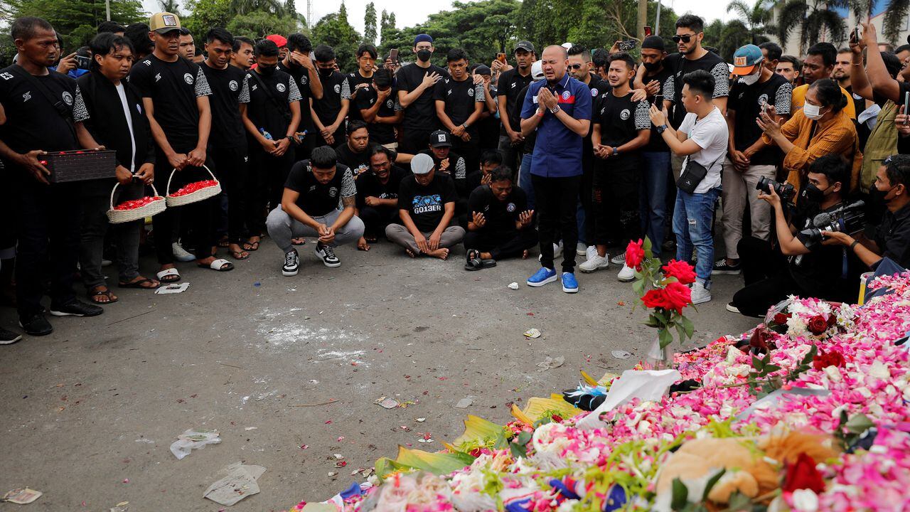 Arema FC players and officials pray as they pay condolence to the victims of the riot and stampede following a soccer match between Arema vs Persebaya, outside the Kanjuruhan stadium in Malang, East Java province, Indonesia, October 3, 2022. REUTERS/Willy Kurniawan