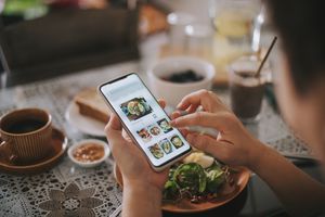 high angle view asian chinese woman's hand on mobile app for online   food delivery during breakfast time