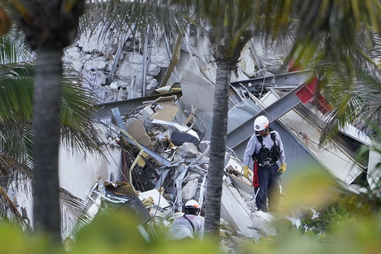 Los rescatistas caminan entre los escombros donde se derrumbó parte de un edificio de condominios frente al mar de 12 pisos, el jueves 24 de junio de 2021, en Surfside, Florida.  (AP Photo/Marta Lavandier)