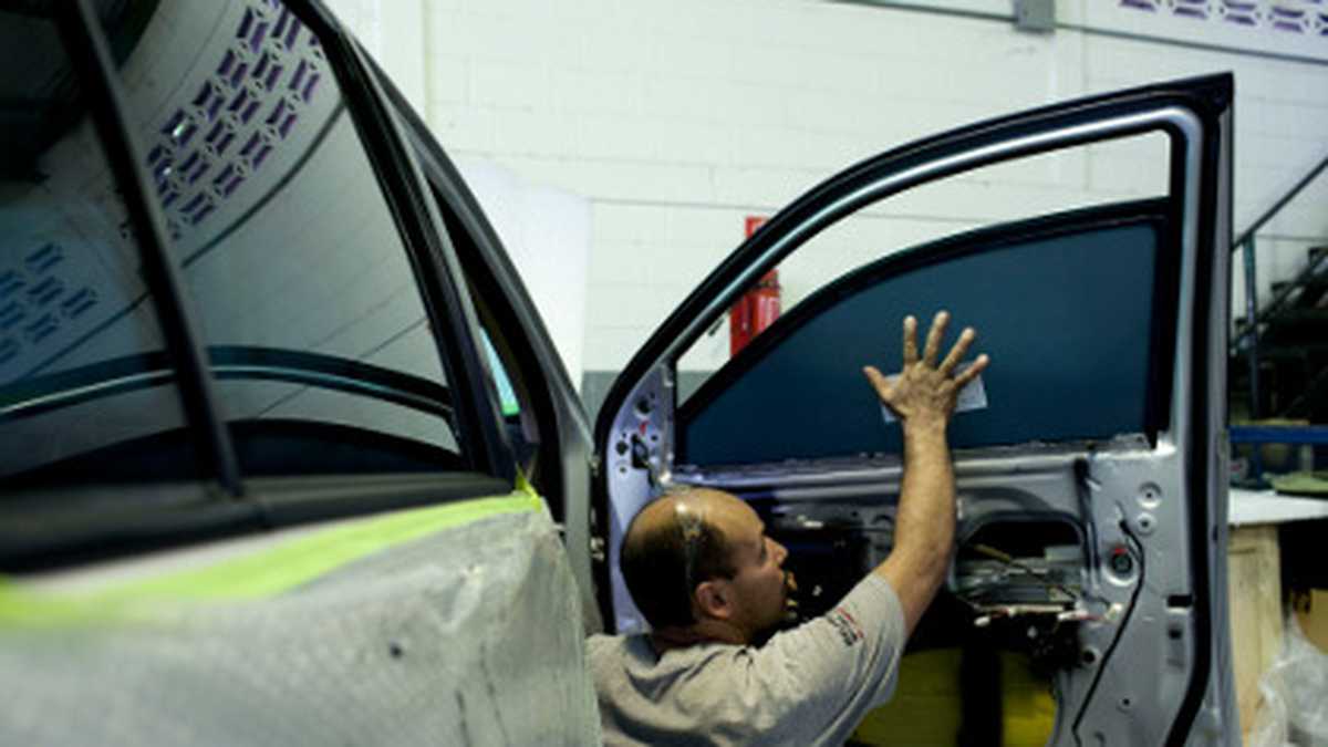 Un hombre instala un vidrio blindado en un carro en Venezuela. 