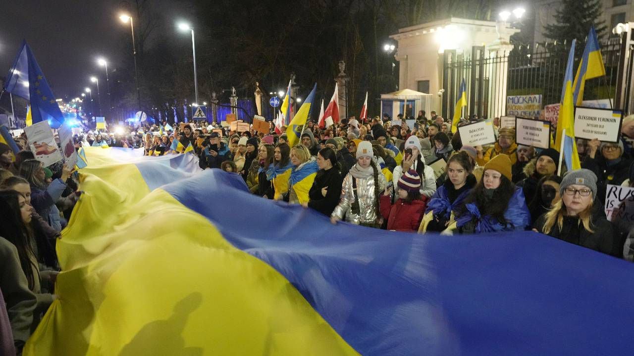Los participantes llevan una bandera ucraniana gigante para conmemorar el primer aniversario de la invasión rusa de Ucrania, frente a la embajada rusa en Varsovia, Polonia, el viernes 24 de febrero de 2023.