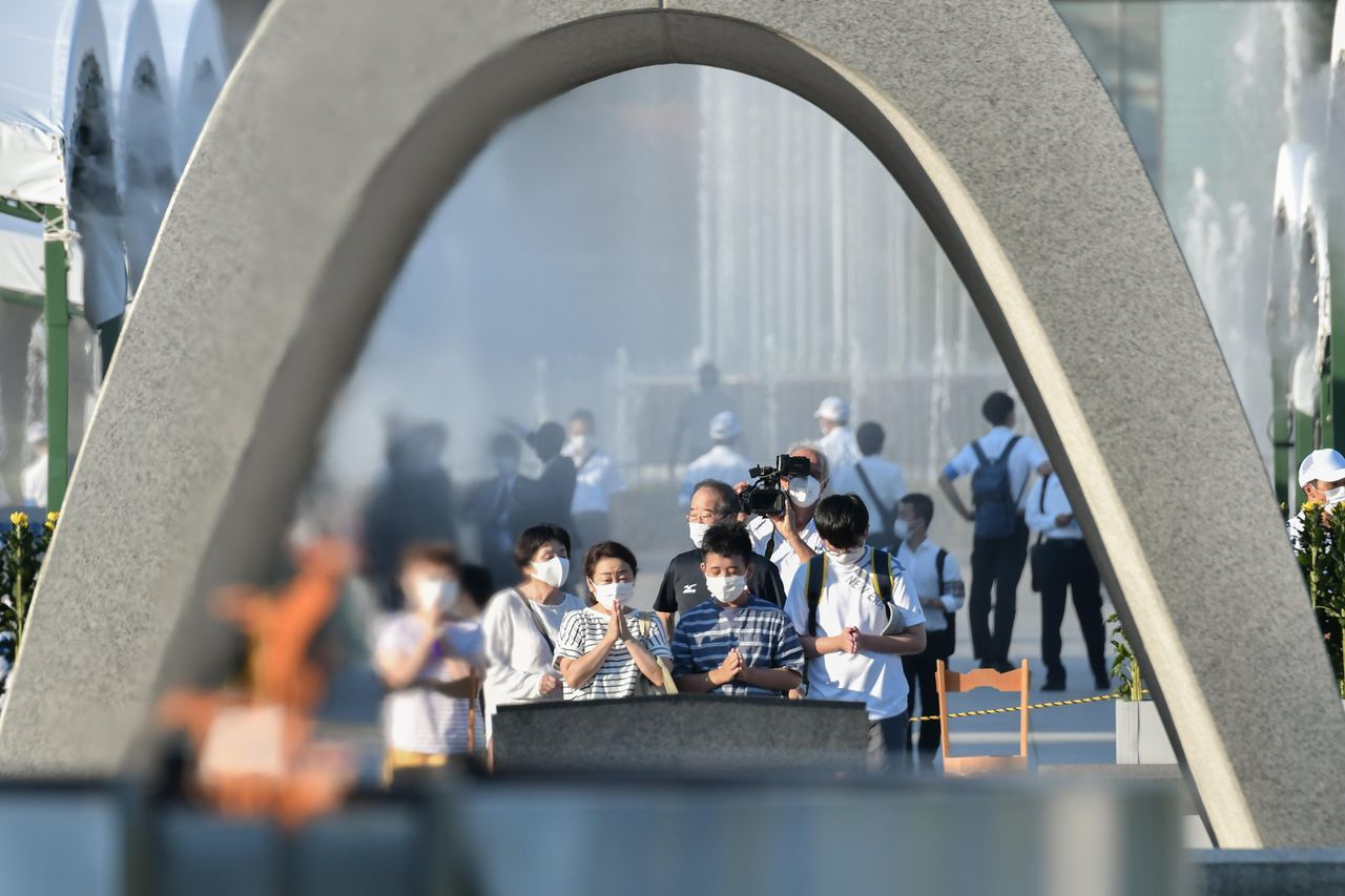 Visitantes oran frente al cenotafio dedicado a las víctimas del bombardeo atómico en el Parque Conmemorativo de la Paz de Hiroshima en Hiroshima, en el oeste de Japón. (Kyodo News via AP)