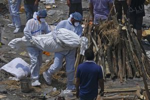 Familiares y trabajadores de salud cargan los cuerpos de muertos por covid-19 en un centro masivo de cremación, New Delhi, India, 27 de abril