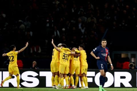 Paris Saint-Germain's French forward #07 Kylian Mbappe (R) reacts as Barcelona's players celebrate scoring their third goal during the UEFA Champions League quarter final first leg football match between Paris Saint-Germain (PSG) and FC Barcelona at the Parc des Princes stadium in Paris on April 10, 2024. (Photo by Anne-Christine POUJOULAT / AFP)