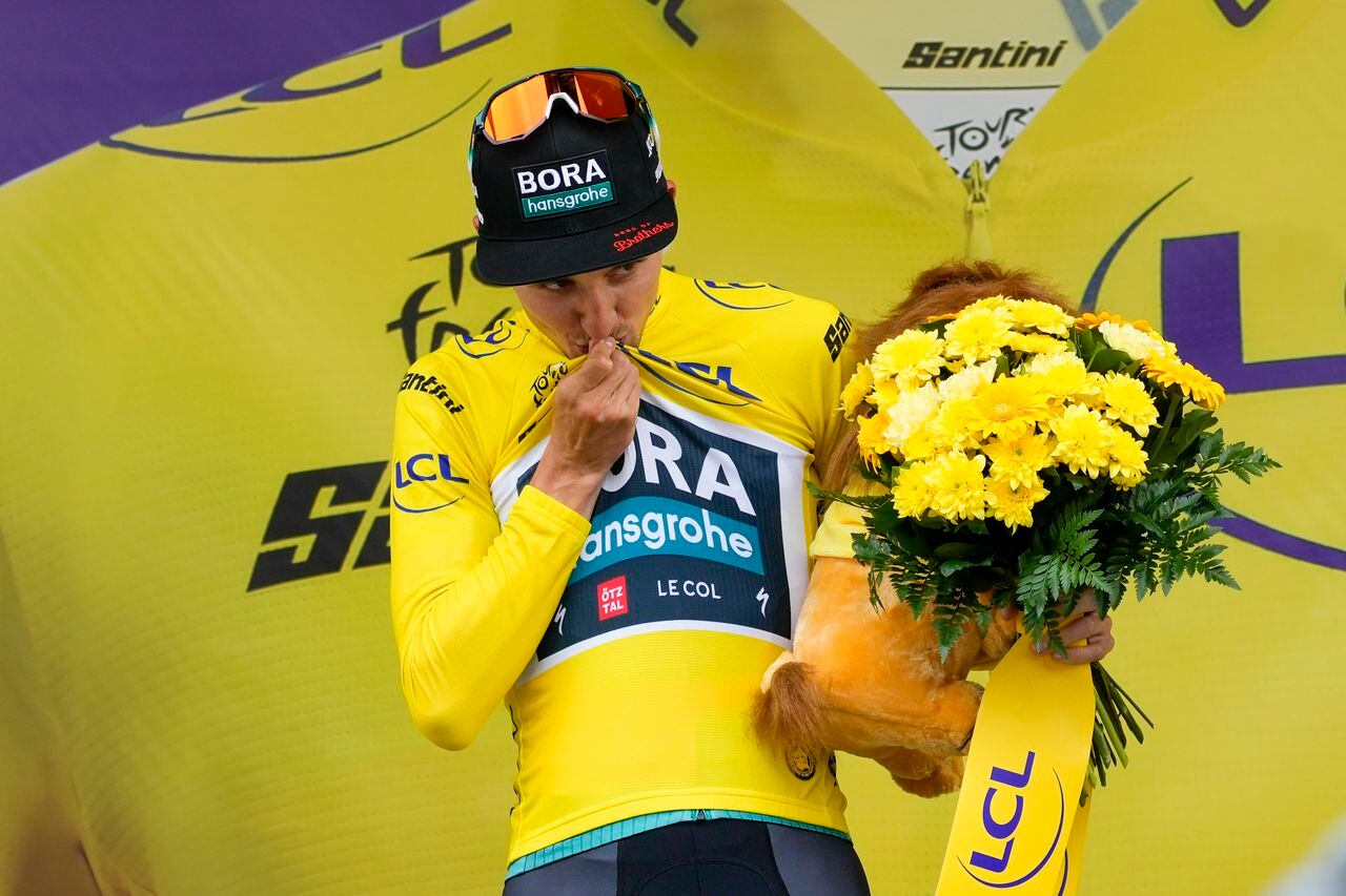 Satge winner Australia's Jai Hindley kisses the overall leader's yellow jersey on the podium after the fifth stage of the Tour de France cycling race over 163 kilometers (101 miles) with start in Pau and finish in Laruns, France, Wednesday, July 5, 2023. (AP Photo/Thibault Camus)