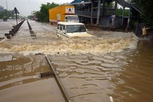 Un viajero conduce su automóvil por una carretera inundada después de fuertes lluvias monzónicas en Gurgaon, en las afueras de Nueva Delhi