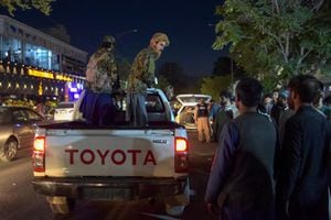 EDITORS NOTE: Graphic content / Taliban fighters stand on a pickup truck outside a hospital as volunteers bring injured people for treatment after two powerful explosions, which killed at least six people, outside the airport in Kabul on August 26, 2021. (Photo by WAKIL KOHSAR / AFP)