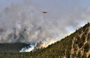 Un avión para combatir incendios vuela sobre un incendio forestal el miércoles 4 de mayo de 2022, cerca de la ciudad de Las Vegas, Nuevo México. (AP Foto/Thomas Peipert)
