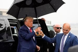 FILE - Valet Walt Nauta hands former President Donald Trump an umbrella before he speaks at Ronald Reagan Washington National Airport, Aug. 3, 2023, in Arlington, Va. The property manager of Donald Trump's Mar-a-Lago estate and an aide to the former president are due back in federal court in Florida to face charges in the case accusing Trump of illegally hoarding classified documents at his club. (AP Photo/Alex Brandon, File)