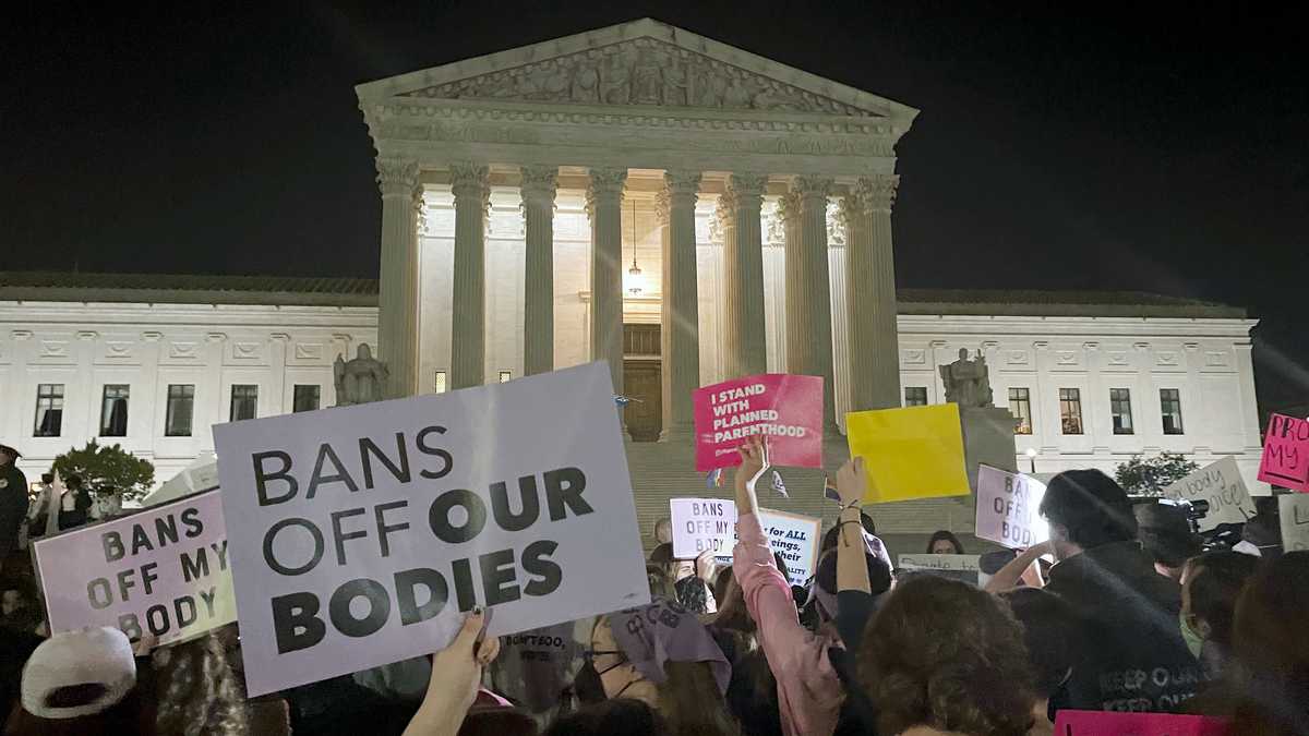 A crowd of people gather outside the Supreme Court, Monday night, May 2, 2022 in Washington. A draft opinion circulated among Supreme Court justices suggests that earlier this year a majority of them had thrown support behind overturning the 1973 case Roe v. Wade that legalized abortion nationwide, according to a report published Monday night in Politico. It’s unclear if the draft represents the court’s final word on the matter.  The Associated Press could not immediately confirm the authenticity of the draft Politico posted, which if verified marks a shocking revelation of the high court’s secretive deliberation process, particularly before a case is formally decided. (AP Photo/Anna Johnson)