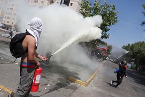 Un manifestante usa un extintor de incendios durante una manifestación en el tercer aniversario de las protestas y disturbios que sacudieron al país en 2019, en Santiago, Chile, el 18 de octubre de 2022.