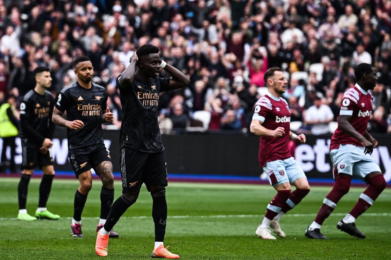 Arsenal's English midfielder Bukayo Saka (C) reacts after missing to score a penalty kick during the English Premier League football match between West Ham United and Arsenal at the London Stadium, in London on April 16, 2023. (Photo by Ben Stansall / AFP) / RESTRICTED TO EDITORIAL USE. No use with unauthorized audio, video, data, fixture lists, club/league logos or 'live' services. Online in-match use limited to 120 images. An additional 40 images may be used in extra time. No video emulation. Social media in-match use limited to 120 images. An additional 40 images may be used in extra time. No use in betting publications, games or single club/league/player publications. /