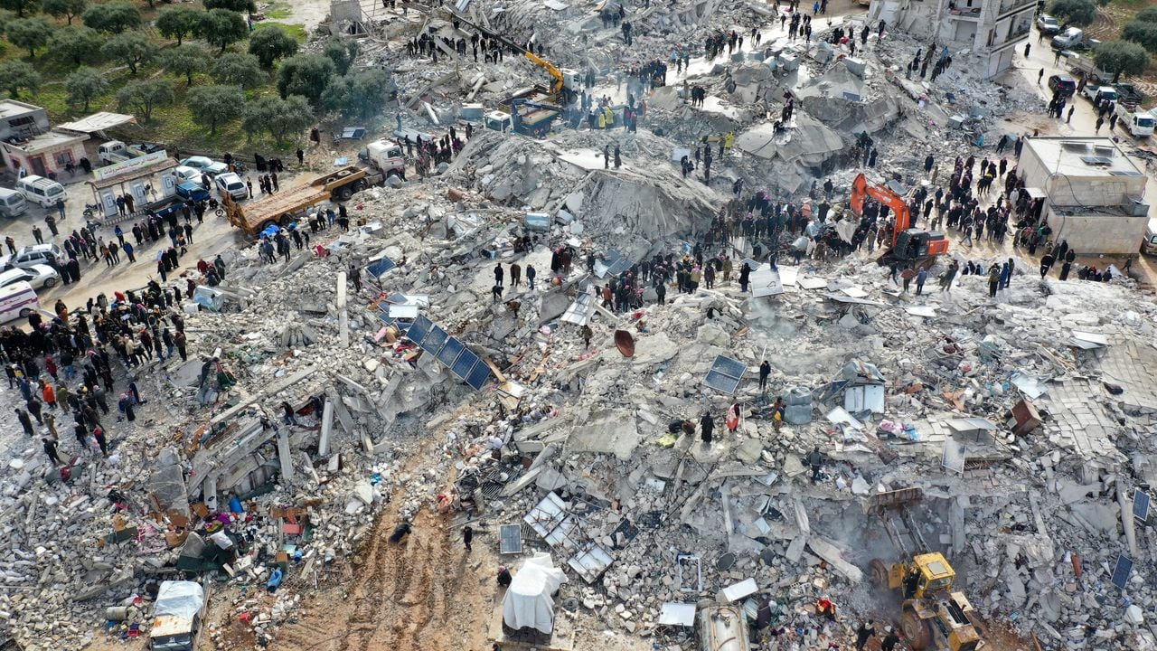 This aerial view shows residents searching for victims and survivors amidst the rubble of collapsed buildings following an earthquake in the village of Besnia near the town of Harim, in Syria's rebel-held noryhwestern Idlib province on the border with Turkey, on February 6, 2022. - Hundreds have been reportedly killed in north Syria after a 7.8-magnitude earthquake that originated in Turkey and was felt across neighbouring countries. (Photo by Omar HAJ KADOUR / AFP)