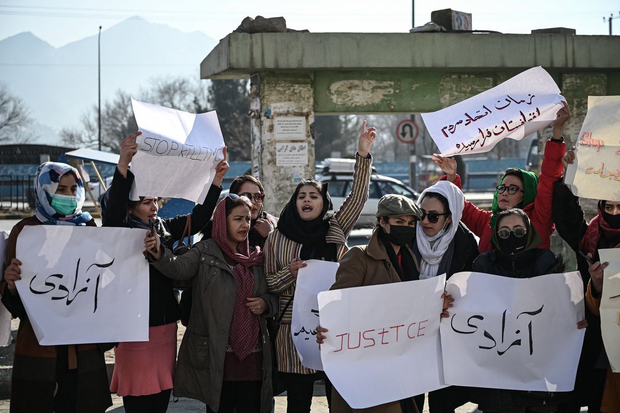 Mujeres sostienen pancartas durante una protesta para exigir el fin de las ejecuciones extrajudiciales de exfuncionarios del régimen anterior, en Kabul el 28 de diciembre de 2021. (Foto de Mohd RASFAN / AFP)