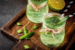 Healthy exotic detox drink, aloe vera or cactus juice with lime, on dark background copy space