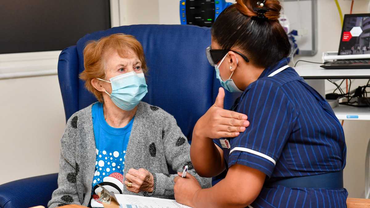 La enfermera May Parsons (R) prepara a Margaret Keenan (L), de 90 años, para ser la primera persona en recibir la vacuna Pfizer / BioNtech Covid-19 en el Hospital Universitario de Coventry, en el centro de Inglaterra, el 8 de diciembre de 2020, cuando Gran Bretaña inicia su mayor evento. programa de inmunización. - Gran Bretaña el 8 de diciembre aclamó un punto de inflexión en la lucha contra la pandemia de coronavirus, ya que comienza el programa de vacunación más grande en la historia del país con un nuevo pinchazo de Covid-19. (Foto de Jacob King / POOL / AFP)