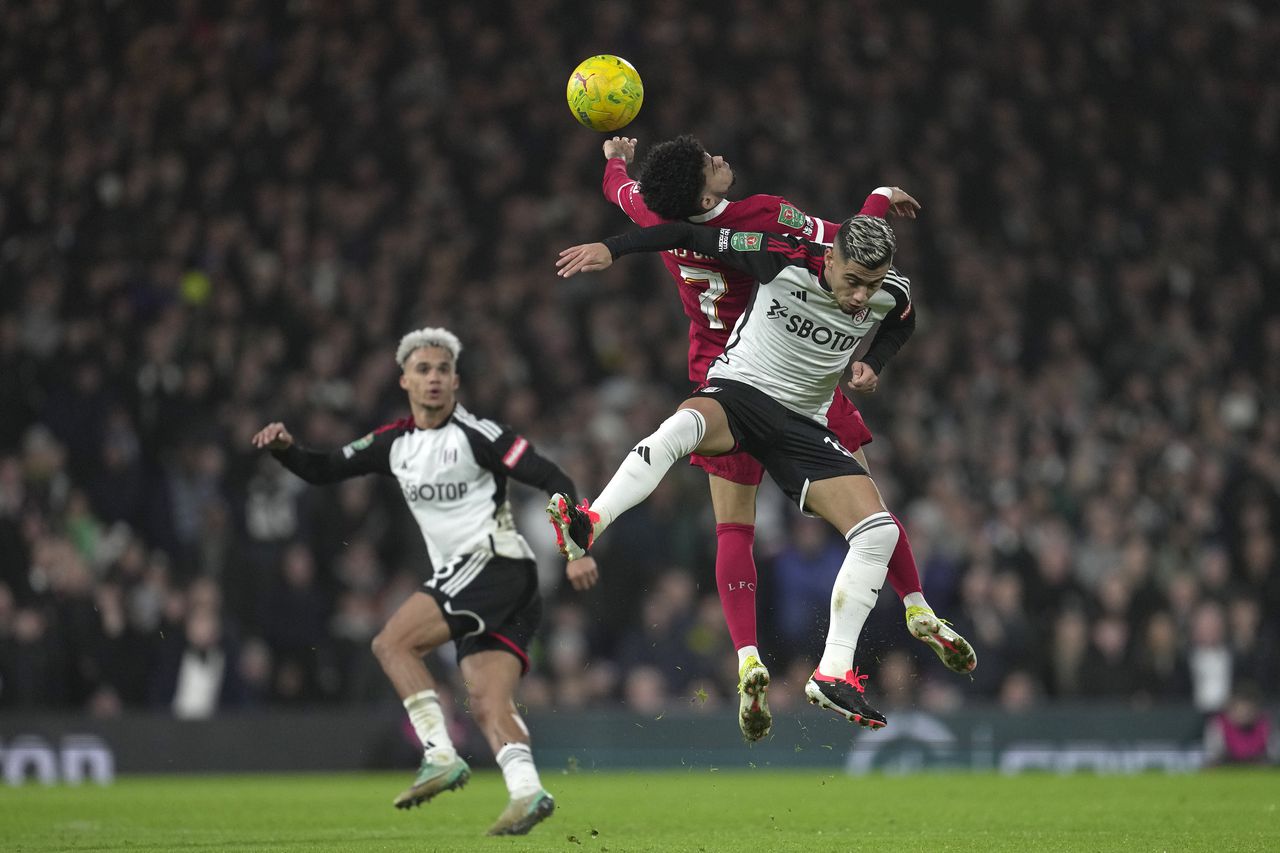 Fulham's Andreas Pereira, right, and Liverpool's Luis Diaz jump for the ball during the English League Cup semi final second leg soccer match between Fulham and Liverpool, at Craven Cottage stadium in London, England, Wednesday, Jan. 24, 2024. (AP Photo/Kin Cheung)