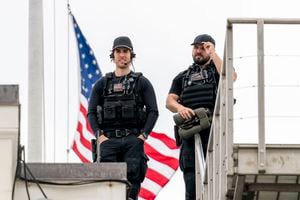 Agentes de policía del Servicio Secreto de los Estados Unidos montan guardia en el techo frente a la bandera estadounidense, mientras se presenta a media asta sobre la Casa Blanca en Washington, el viernes 16 de abril de 2021. Foto: AP / Andrew Harnik.