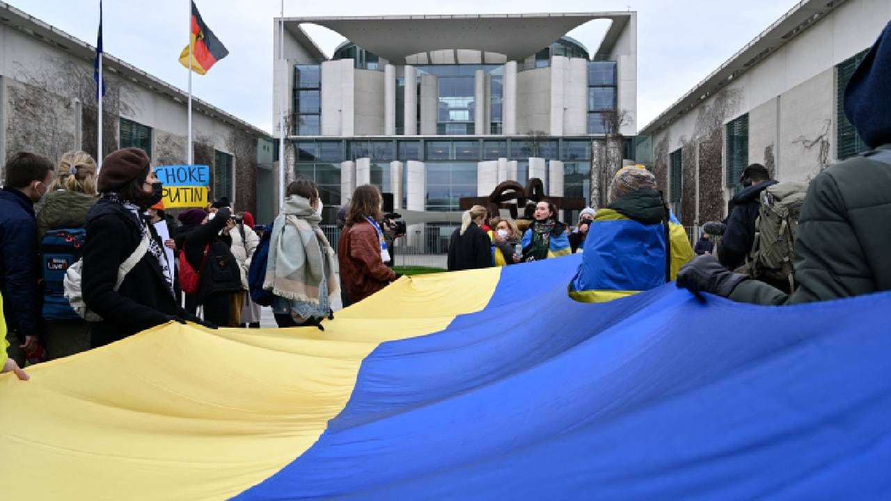 Los manifestantes muestran una bandera ucraniana gigante frente a la Cancillería en Berlín mientras protestan el 24 de febrero de 2022 contra la invasión rusa de Ucrania.