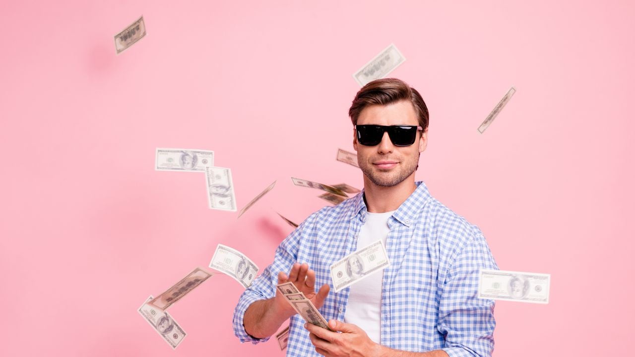 Portrait of his he nice cool trendy content attractive handsome candid guy wearing checked shirt throwing money flying in air party wealth isolated over pink pastel background