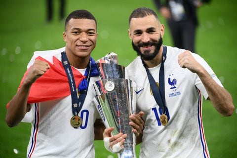 France's forward Kylian Mbappe (L) and France's forward Karim Benzema (R) celebrate with the trophy at the end of the Nations League final football match between Spain and France at San Siro stadium in Milan, on October 10, 2021. (Photo by FRANCK FIFE / AFP)