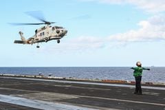 Esta foto tomada el 31 de enero de 2024 muestra un helicóptero SH-60K de la Fuerza de Autodefensa Marítima de Japón aterrizando en la cubierta del portaaviones USS Carl Vinson durante un ejercicio marítimo de tres días entre Estados Unidos y Japón en el Mar de Filipinas. Una importante operación de búsqueda continuó frente a Japón el 22 de abril de 2024 para buscar a siete personas desaparecidas después de que dos helicópteros SH-60K de la marina aparentemente chocaran durante el fin de semana, y se confirmó la muerte de un miembro de la tripulación.
