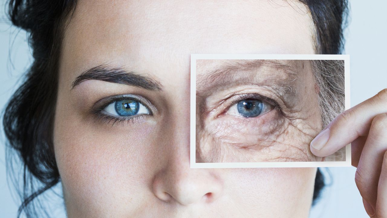 Young woman with photo of aged eye over her own