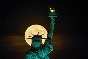 La superluna de fresa se eleva frente a la Estatua de la Libertad en Nueva York, el martes 14 de junio de 202. Foto AP/J. David Ake