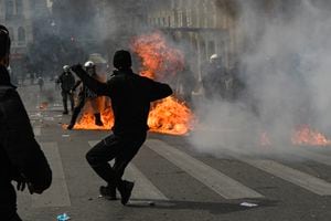 Protesters throw stones and molotov towards riot police in the center of the capital, as clashes broke-out during a 24-hour strike in Athens on March 16, 2023. - Greek police fired tear gas and protesters hurled firebombs on March 16, 2023, as more than 40,000 people took to the streets to slam the government and voice outrage at last month's train disaster that killed 57 people. The February 28 tragedy exposed decades of safety failings in Greek railways and has put major pressure on the conservative government ahead of national elections. (Photo by Louisa GOULIAMAKI / AFP)