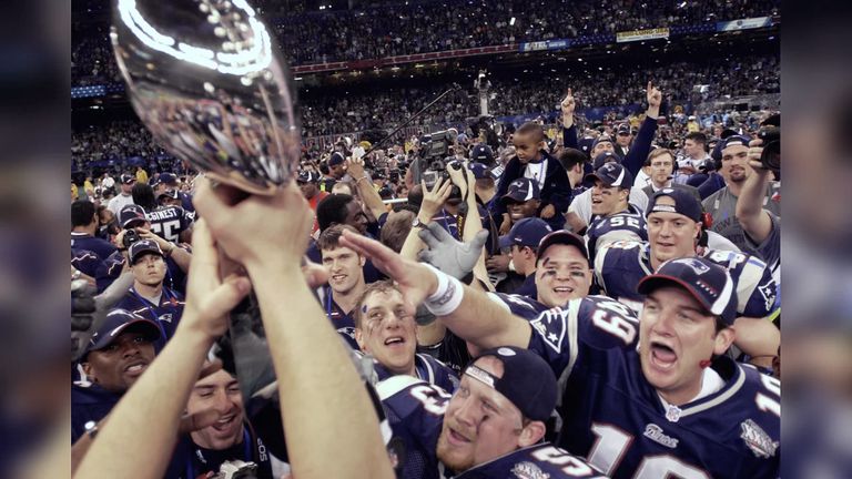 New England Patriots players reach out to touch the Vince Lombardy Trophy after beat the St. Louis Rams, 20-17, to win Super Bowl XXXVI on Sunday, Feb 3, 2002, in New Orleans. David J. Phillips/ Associated Press/ 2002.