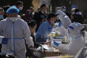 Los residentes se toman una muestra de la garganta en un sitio de prueba de coronavirus cerca de edificios residenciales luego de que se detectó un caso de COVID-19 en el área, el jueves 7 de abril de 2022, en Beijing. (AP Photo/Andy Wong)