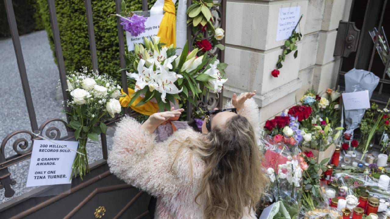 Una mujer reacciona después de colocar un ramo de flores en la puerta de la casa de la fallecida cantante, Tina Turner.