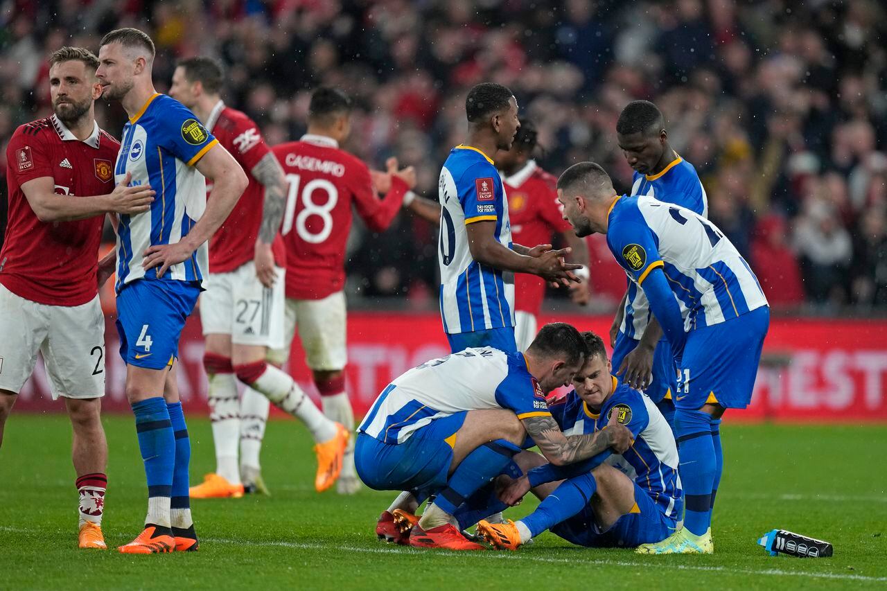 Brighton's Lewis Dunk consoles Brighton's Solly March after he missed during a penalty shootout at the end of the English FA Cup semifinal soccer match between Brighton and Hove Albion and Manchester United at Wembley Stadium in London, Sunday, April 23, 2023. (AP/Alastair Grant)