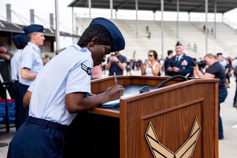 La aviadora de primera clase D'elbrah Assamoi, de Costa de Marfil, firma su certificado de ciudadanía estadounidense