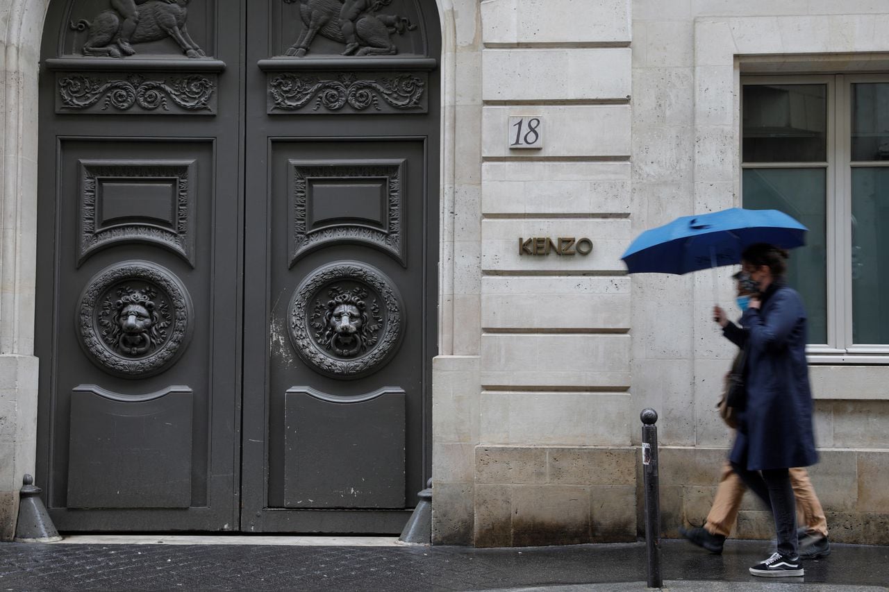 La gente pasa por delante de la casa de moda Kenzo, con sede en París, el 4 de octubre de 2020 en París, el día en que el diseñador de moda japonés Kenzo Takada, fundador de la marca global Kenzo, murió en París después de contraer Covid-19