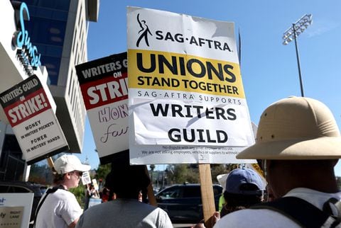LOS ANGELES, CALIFORNIA - JULY 13: A sign reads 'Unions Stand Together' as SAG-AFTRA members walk the picket line in solidarity with striking WGA (Writers Guild of America) workers outside Netflix offices on July 13, 2023 in Los Angeles, California. Members of SAG-AFTRA, Hollywood�s largest union which represents actors and other media professionals, will likely go on strike after a midnight deadline over contract negotiations with studios expired. The strike could shut down Hollywood productions completely with writers in the third month of their strike against Hollywood studios.   Mario Tama/Getty Images/AFP (Photo by MARIO TAMA / GETTY IMAGES NORTH AMERICA / Getty Images via AFP)